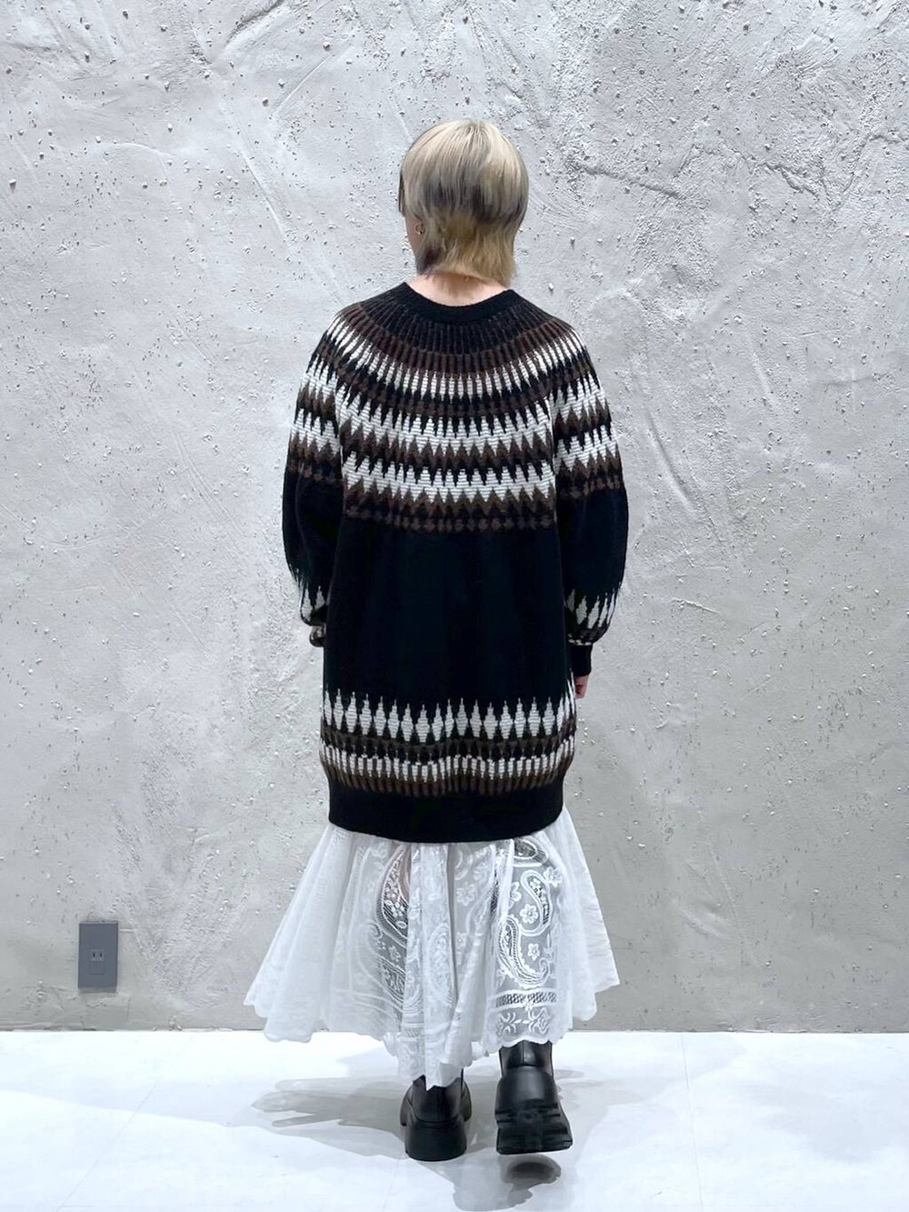 ホワイト系のスカート、ブラック系のブーツ、ブラック系のワンピースを着用したレディースの冬コーディネートの3枚目の写真