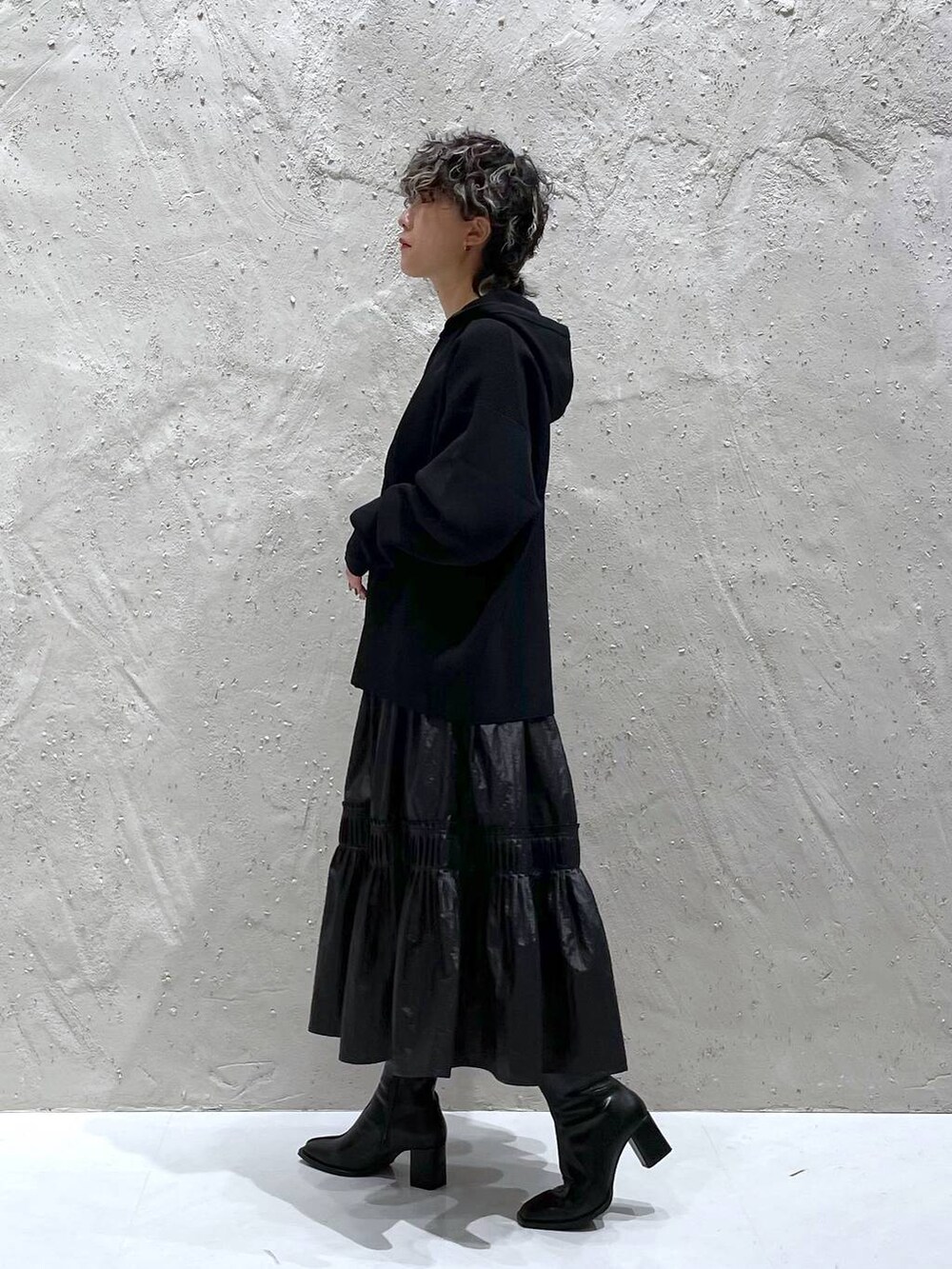 ブラック系のパンプス、ブラック系のニット/セーター、ブラック系のスカートを着用したレディースの秋コーディネートの2枚目の写真