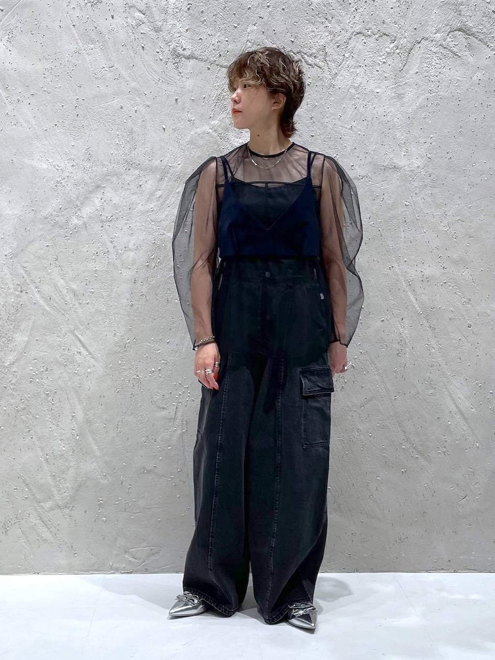 ブラック系のデニムパンツ、シルバー系のパンプス、ブルー系のベストを着用したレディースの夏コーディネートの5枚目の写真