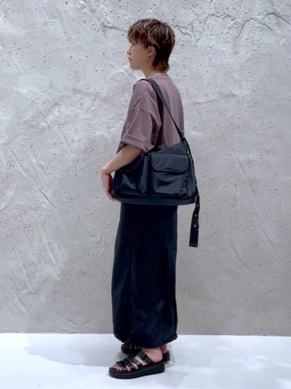 ブラック系のデニムスカート、ブラック系のショルダーバッグ、ブラック系のスニーカーを着用したレディースの夏コーディネートの2枚目の写真