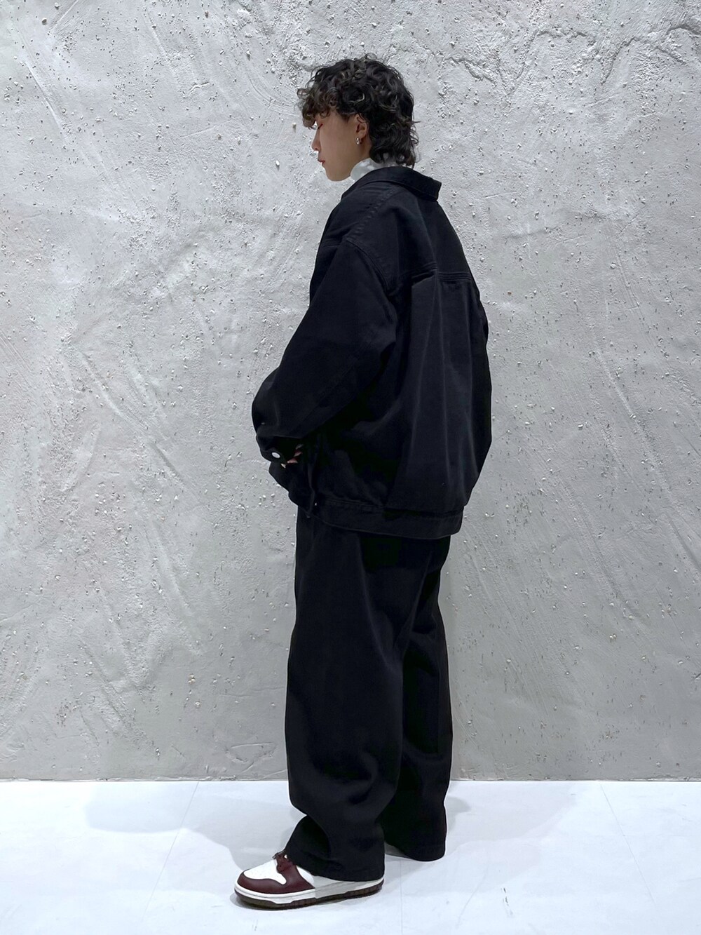 ブラック系のデニムジャケット、ブラック系のデニムパンツ、ホワイト系のTシャツ/カットソーを着用したレディースの冬コーディネートの3枚目の写真