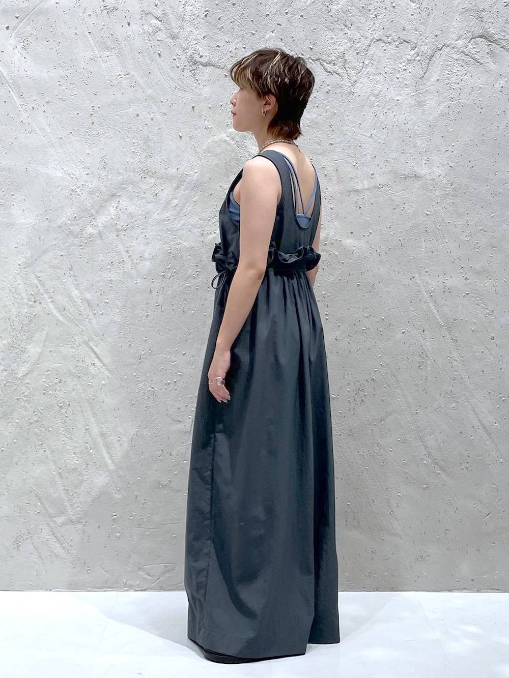 ブラック系のスニーカー、グレー系のワンピースを着用したレディースの夏コーディネートの2枚目の写真