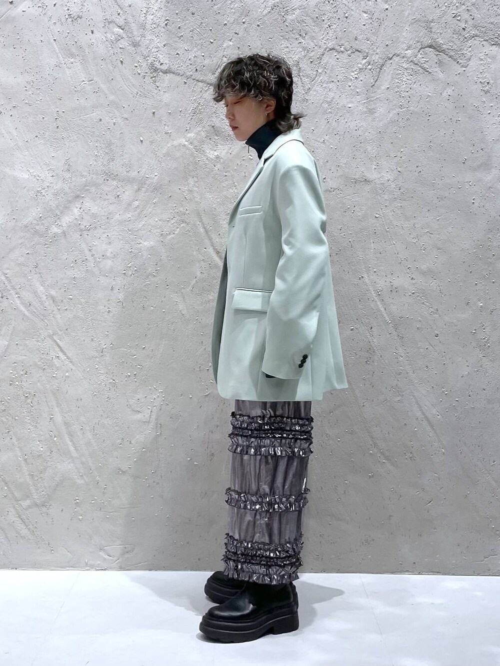 グリーン系のテーラードジャケット、シルバー系のスカート、グレー系のニット/セーターを着用したレディースの春コーディネートの4枚目の写真