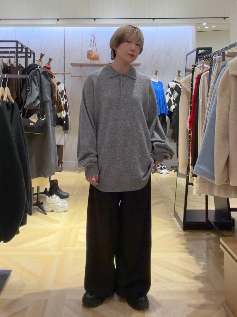 ブラック系のブーツ、グレー系のニット/セーター、ブラック系のスラックスを着用したレディースの秋コーディネートの3枚目の写真