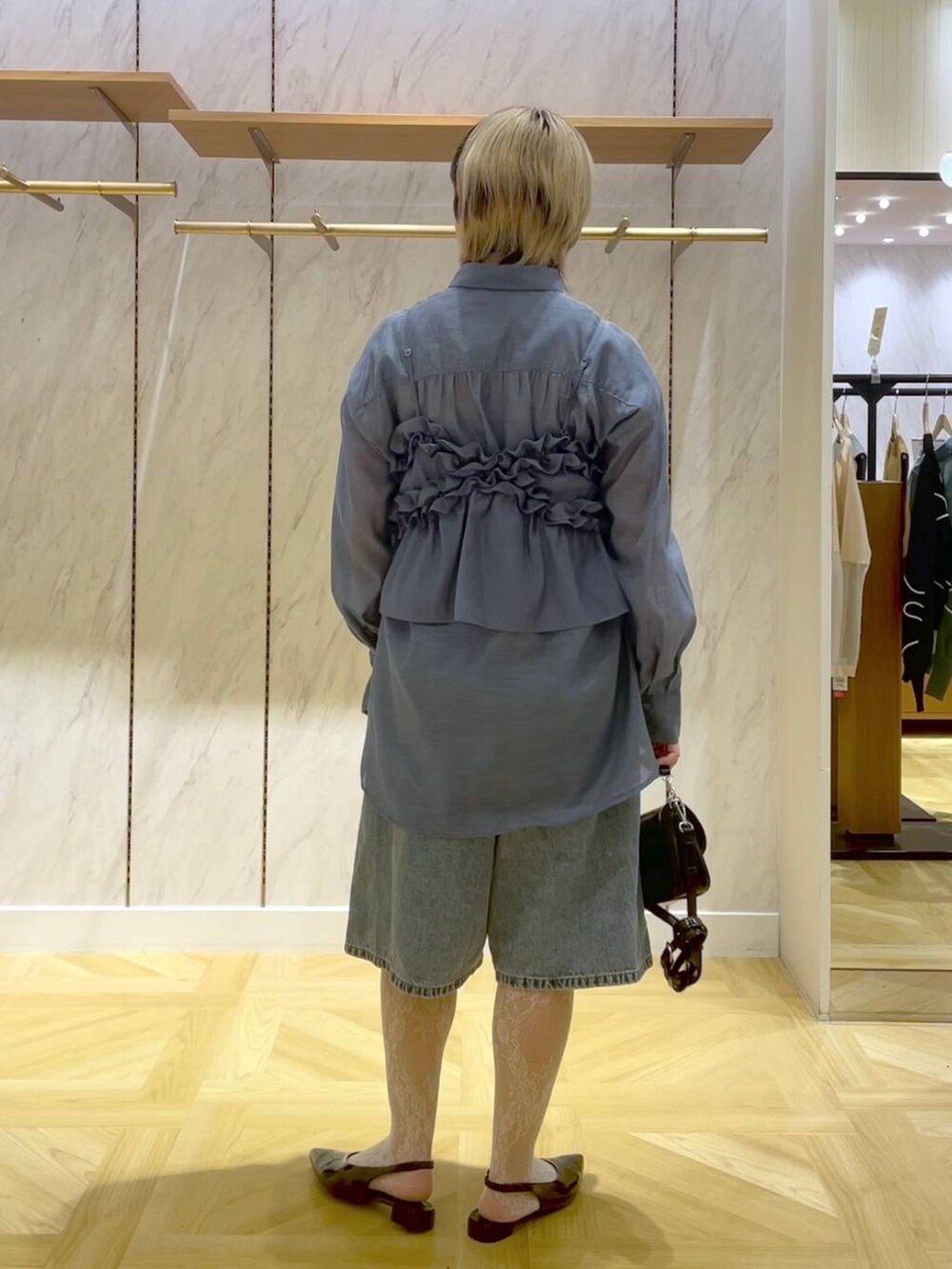 ブルー系のシャツ/ブラウス、ブルー系のキャミソール、ブラック系のショルダーバッグを着用したレディースの春コーディネートの3枚目の写真