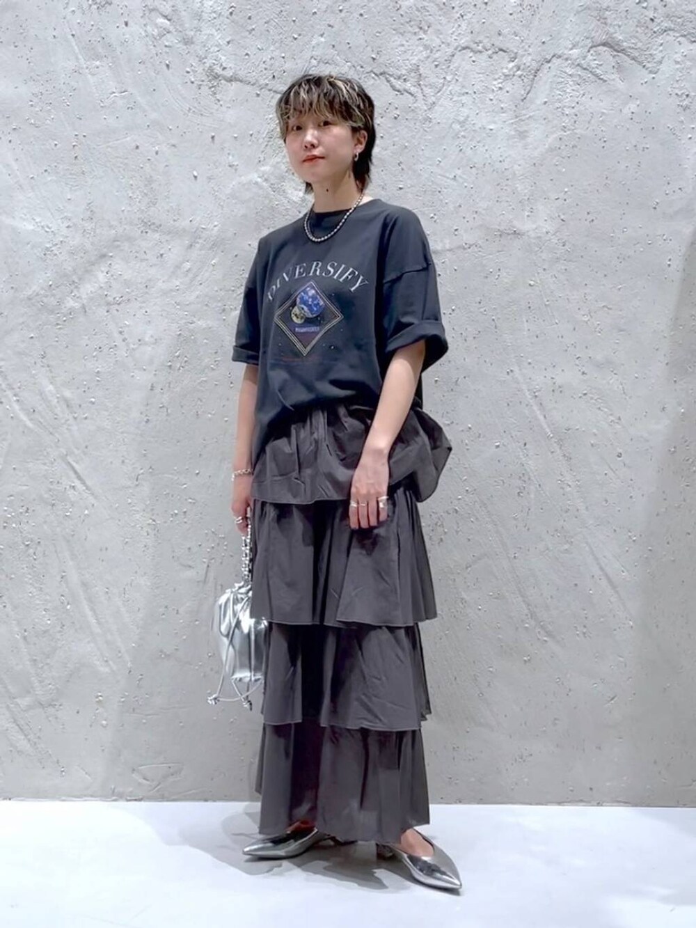 シルバー系のパンプス、シルバー系のショルダーバッグ、ブラック系のTシャツ/カットソーを着用したレディースの夏コーディネートの5枚目の写真