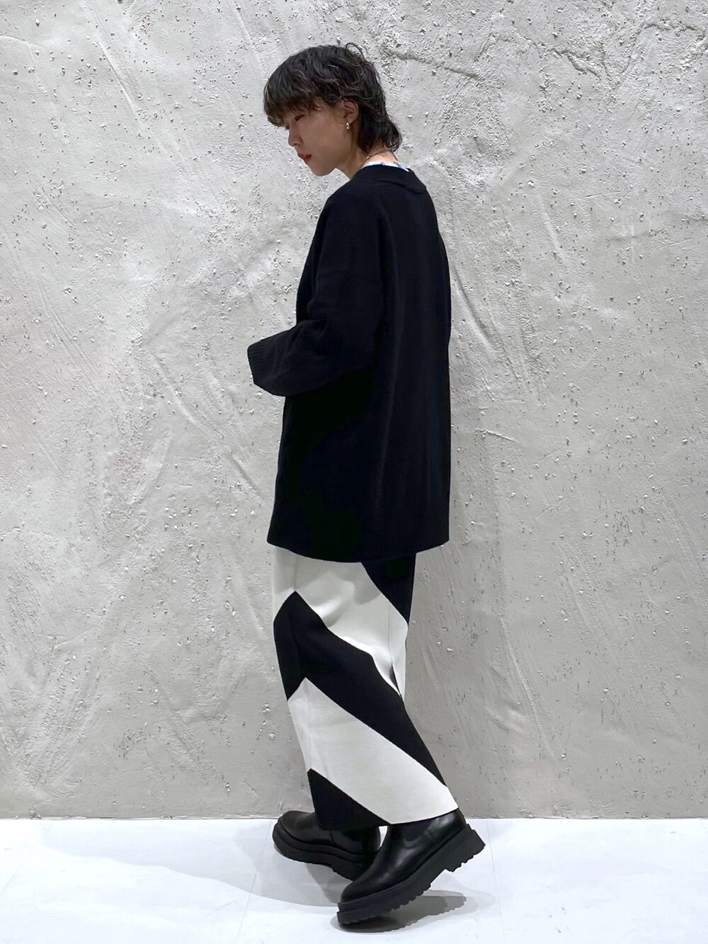 ブルー系のTシャツ/カットソー、ブラック系のカーディガン/ボレロ、ブラック系のスカートを着用したレディースの冬コーディネートの2枚目の写真