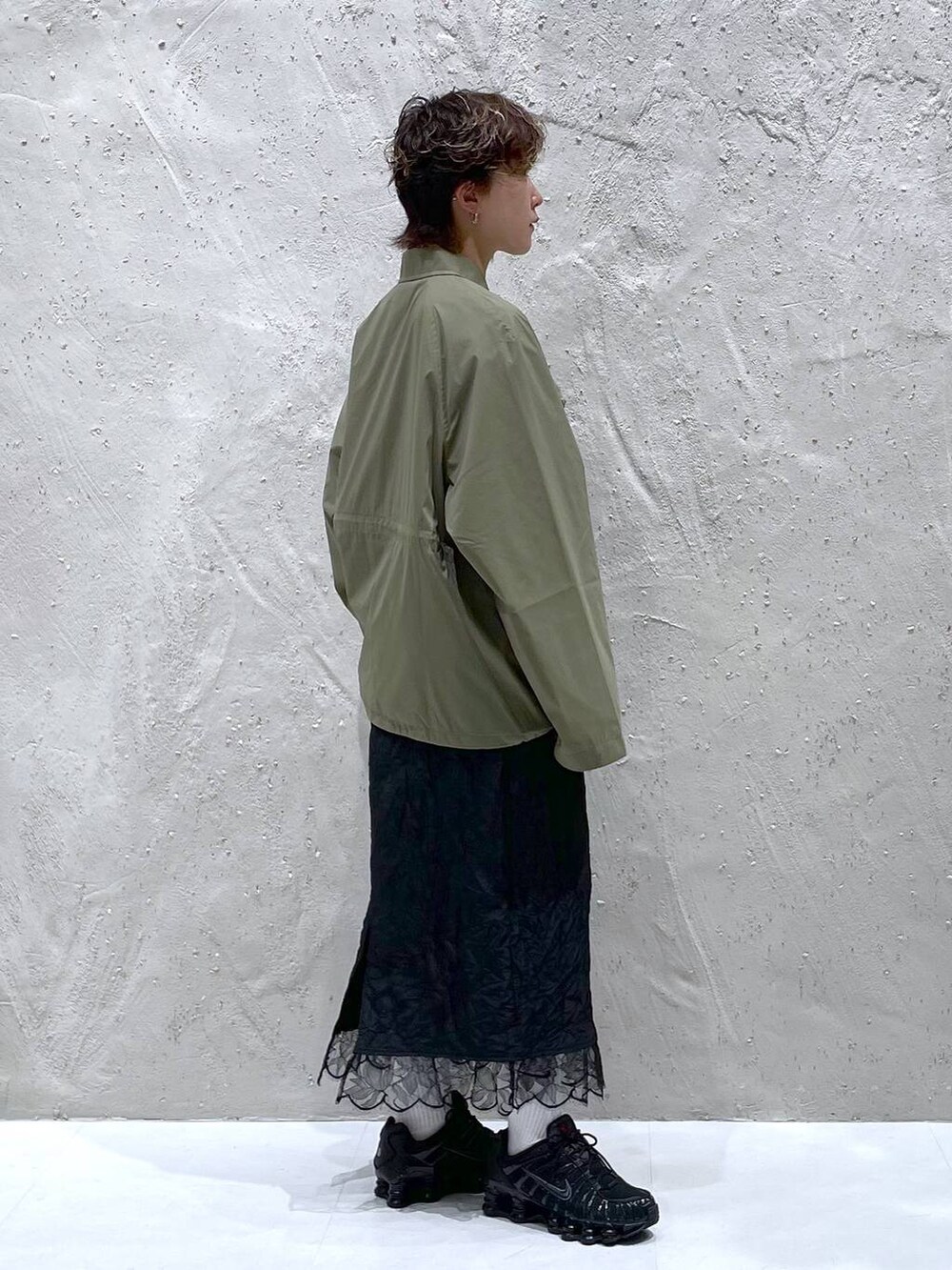 グリーン系のブルゾン、ブラック系のスカートを着用したレディースの夏コーディネートの4枚目の写真