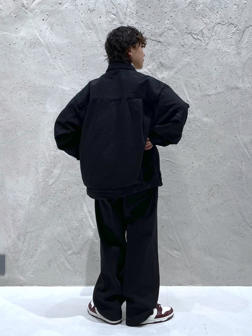 ブラック系のデニムジャケット、ブラック系のデニムパンツ、ホワイト系のTシャツ/カットソーを着用したレディースの冬コーディネートの2枚目の写真