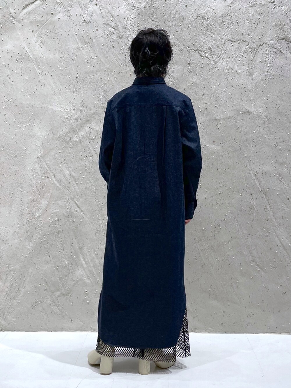 ブルー系のシャツワンピース、ブラック系のスカート、ホワイト系のブーツを着用したレディースの春コーディネートの3枚目の写真