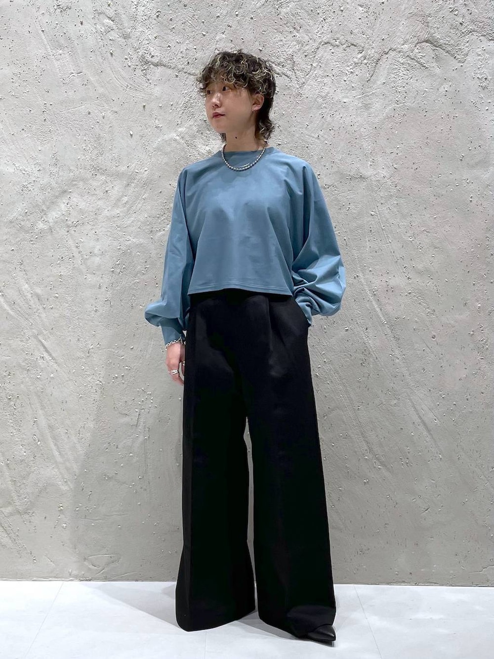 ブラック系のブルゾン、ブラック系のブーツ、ブルー系のTシャツ/カットソーを着用したレディースの冬コーディネートの6枚目の写真