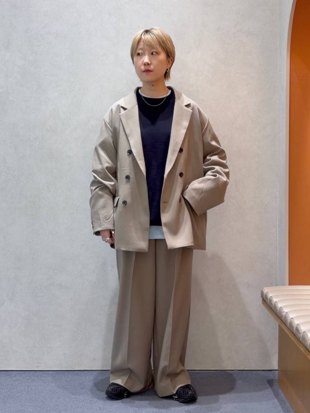 ブルー系のニット/セーター、ベージュ系のスラックス、ベージュ系のテーラードジャケットを着用したメンズの春コーディネートの4枚目の写真