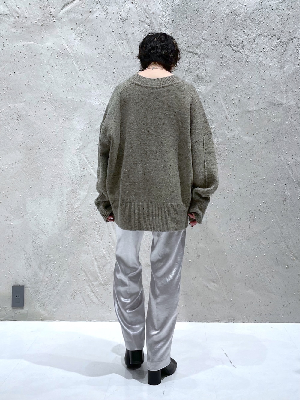 ベージュ系のニット/セーター、シルバー系のその他パンツ、ブラック系のブーツを着用したレディースの冬コーディネートの3枚目の写真