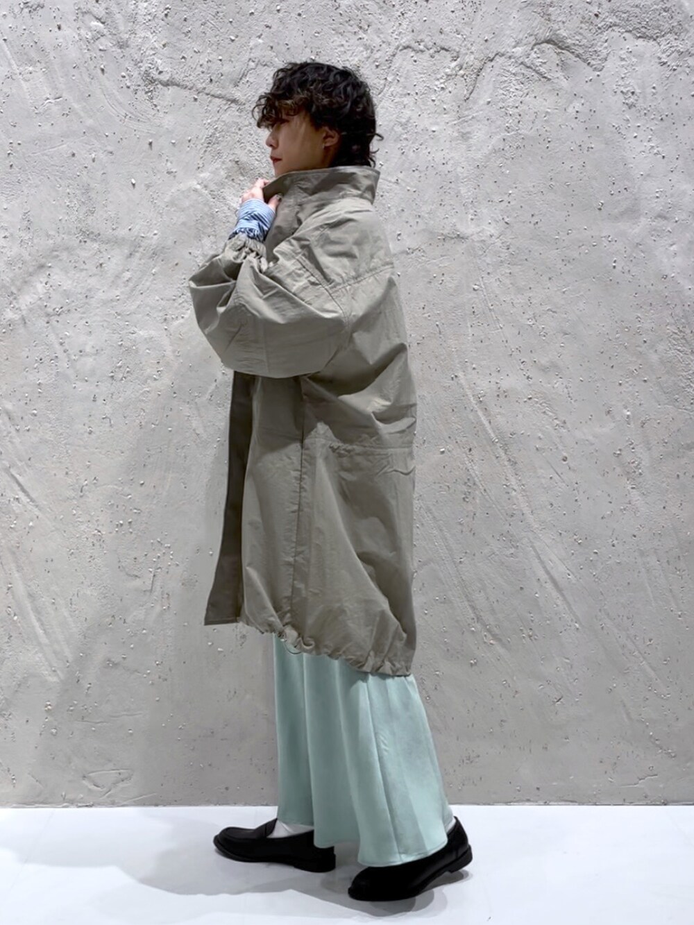 グリーン系のナイロンジャケット、ブルー系のシャツ/ブラウス、グリーン系のスカートを着用したレディースの冬コーディネートの2枚目の写真