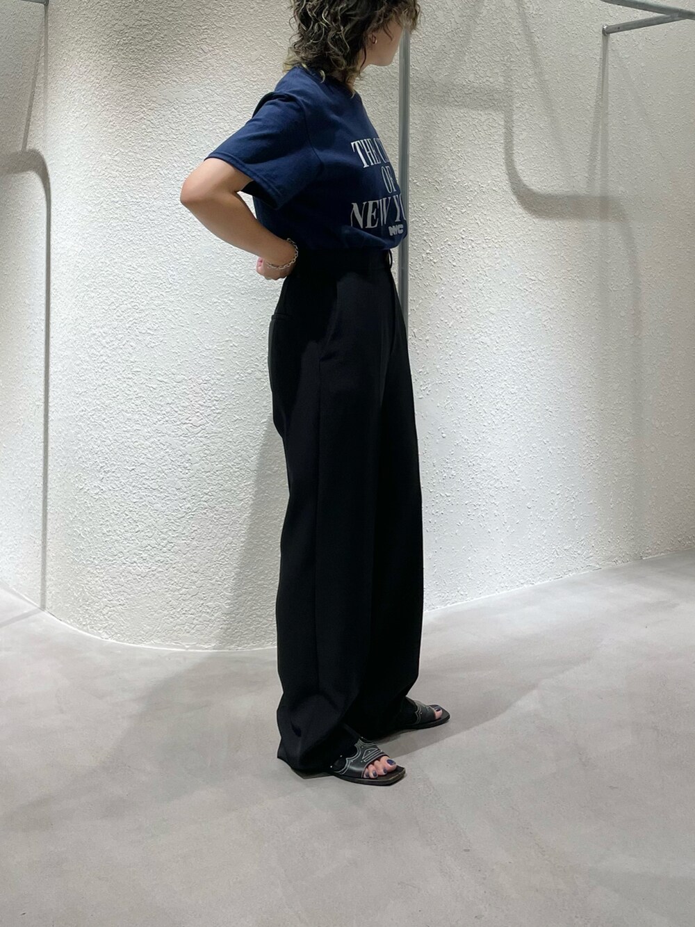 ブルー系のTシャツ/カットソー、ブラック系のスラックス、シルバー系のブレスレットを着用したレディースの夏コーディネートの2枚目の写真