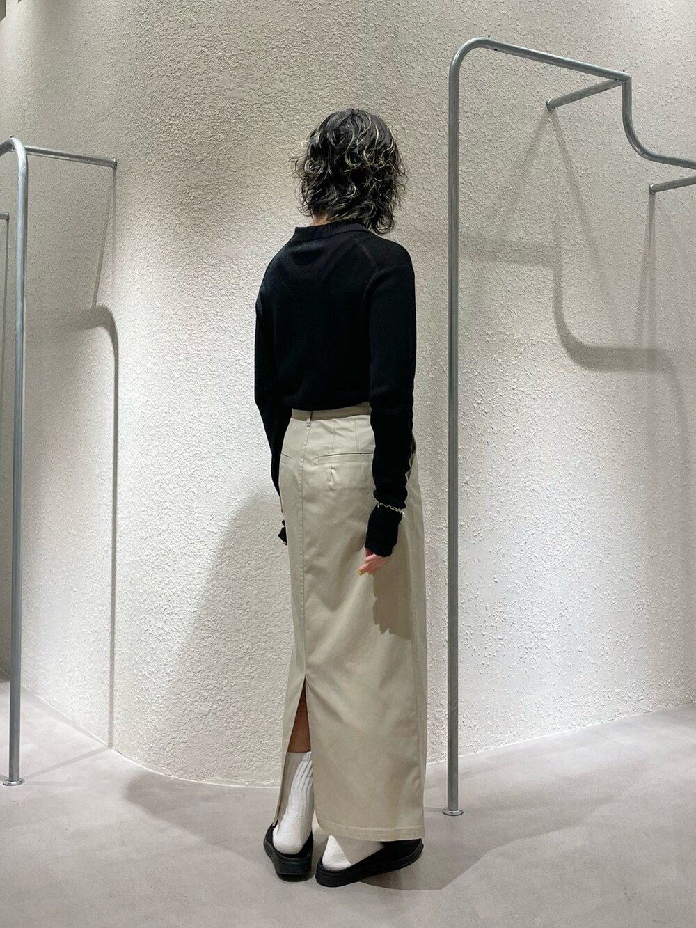 ブラック系のカーディガン/ボレロ、ベージュ系のスカート、ブラック系のローファーを着用したレディースの夏コーディネートの3枚目の写真