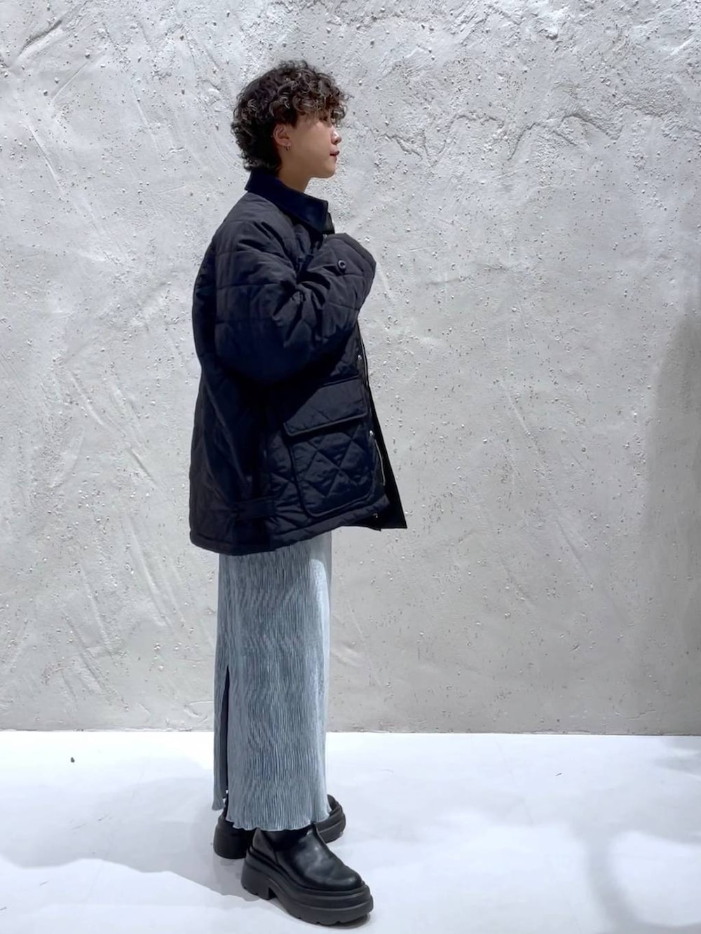 ブルー系のTシャツ/カットソー、ブラック系のブーツ、ホワイト系のハンドバッグを着用したレディースの冬コーディネートの4枚目の写真