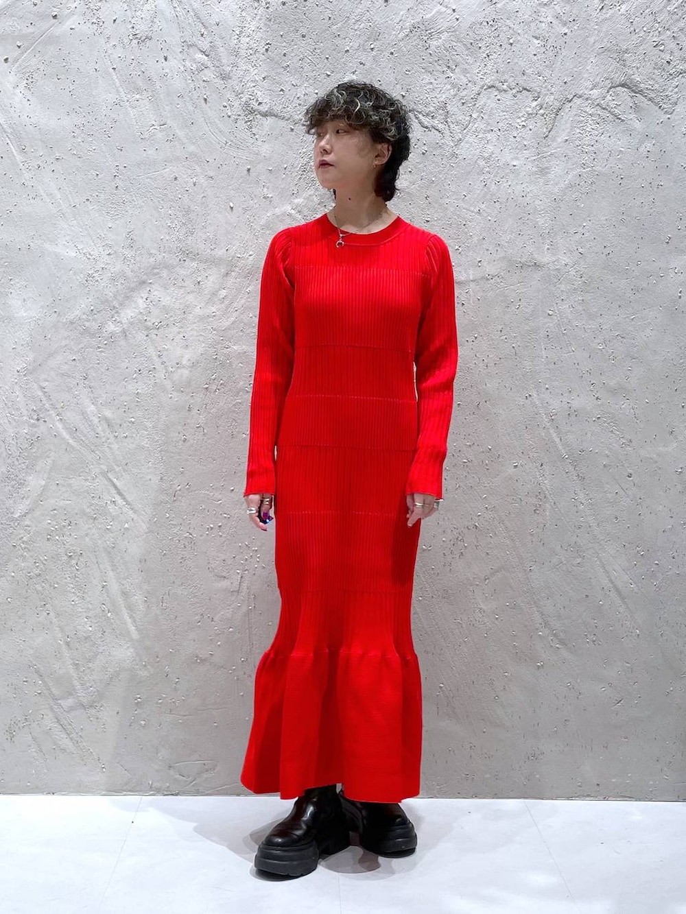 ブラック系のブーツ、ブラウン系のその他アウター、レッド系のワンピースを着用したレディースの冬コーディネートの6枚目の写真