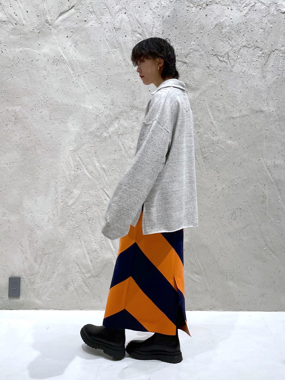 ホワイト系のスウェット、ブルー系のスカート、ブラック系のブーツを着用したレディースの冬コーディネートの3枚目の写真