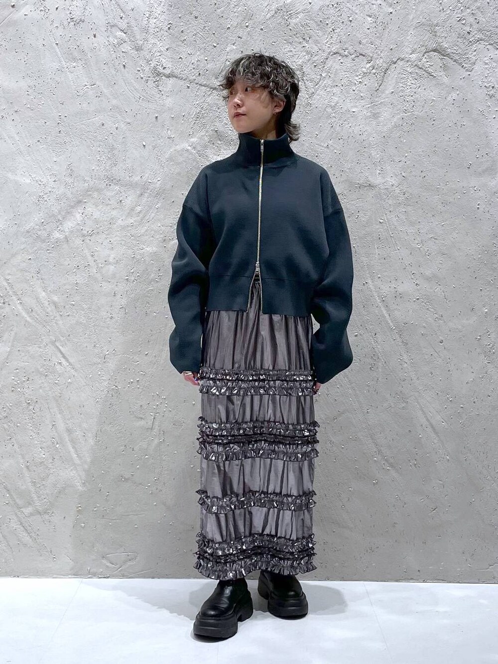 グリーン系のテーラードジャケット、シルバー系のスカート、グレー系のニット/セーターを着用したレディースの春コーディネートの9枚目の写真