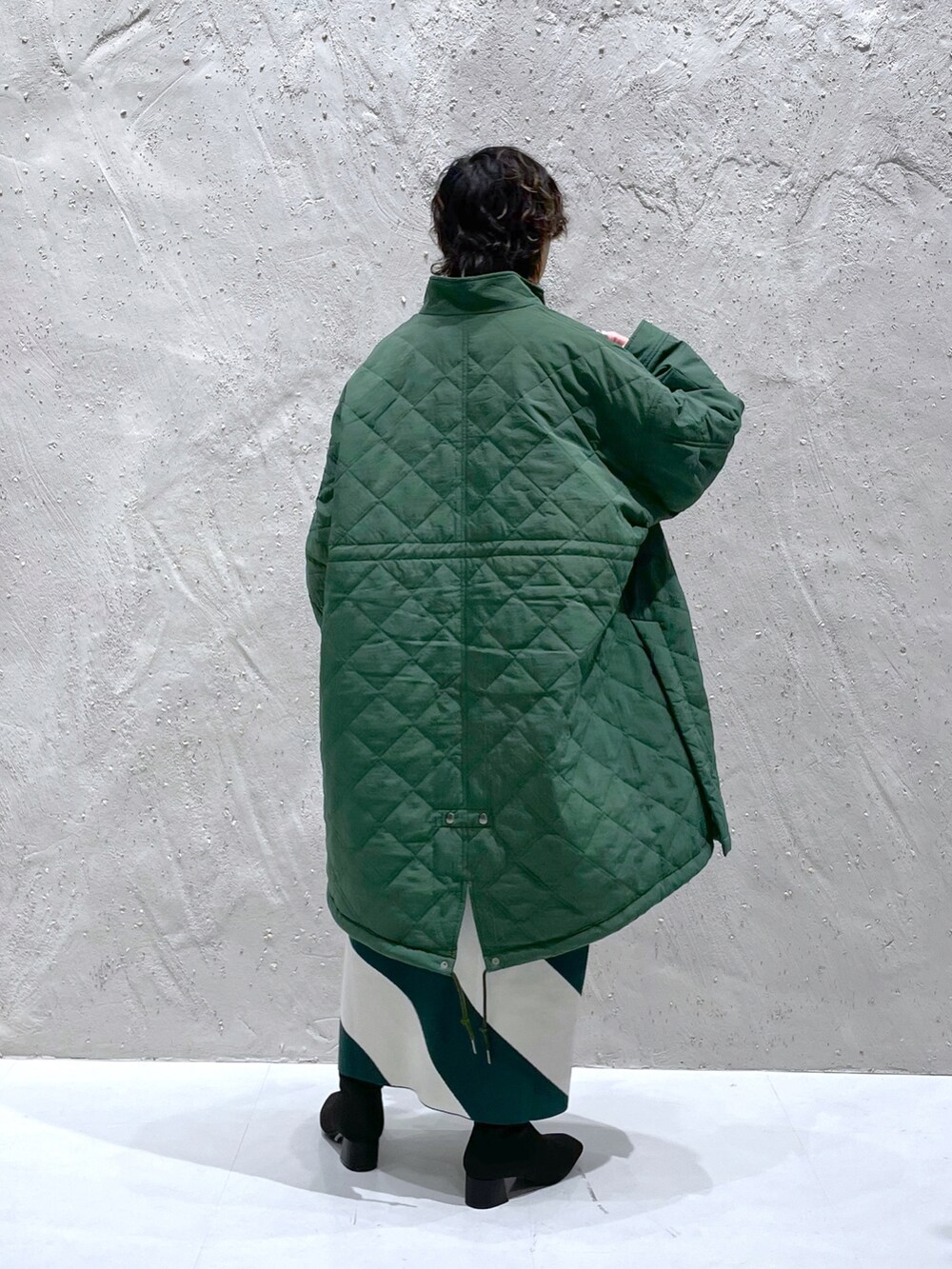 グリーン系のミリタリージャケット、ブラック系のパンプス、グリーン系のワンピースを着用したレディースの冬コーディネートの3枚目の写真