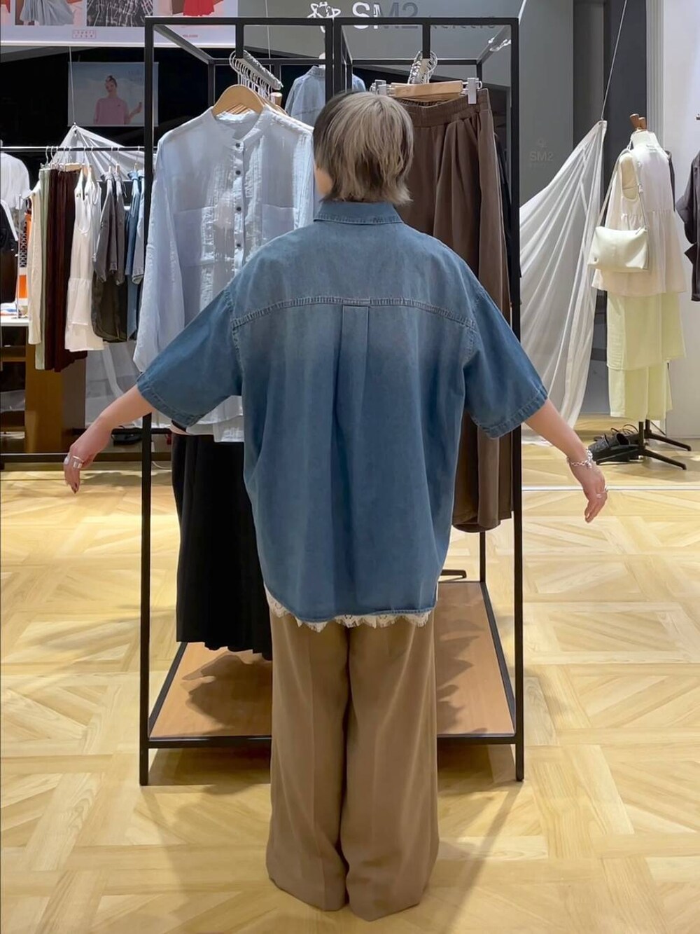 レッド系のサンダル、ブルー系のシャツ/ブラウス、ベージュ系のスラックスを着用したレディースの春コーディネートの3枚目の写真