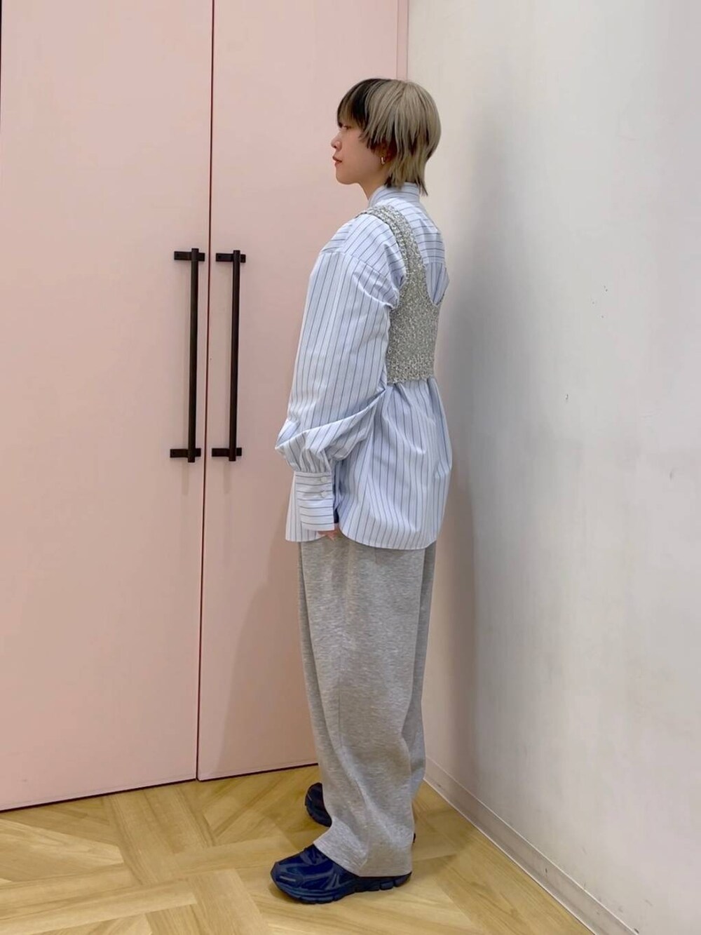 ブルー系のシャツ/ブラウス、グレー系のスウェットパンツ、グレー系のニット/セーターを着用したレディースの冬コーディネートの2枚目の写真