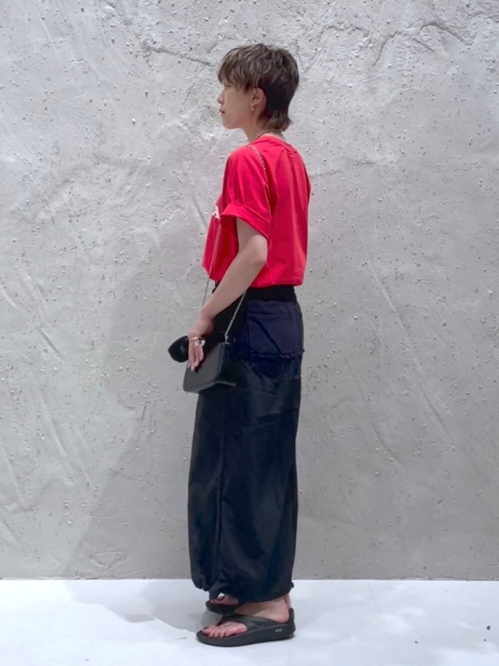 ブラック系のデニムスカート、レッド系のTシャツ/カットソーを着用したレディースの夏コーディネートの2枚目の写真