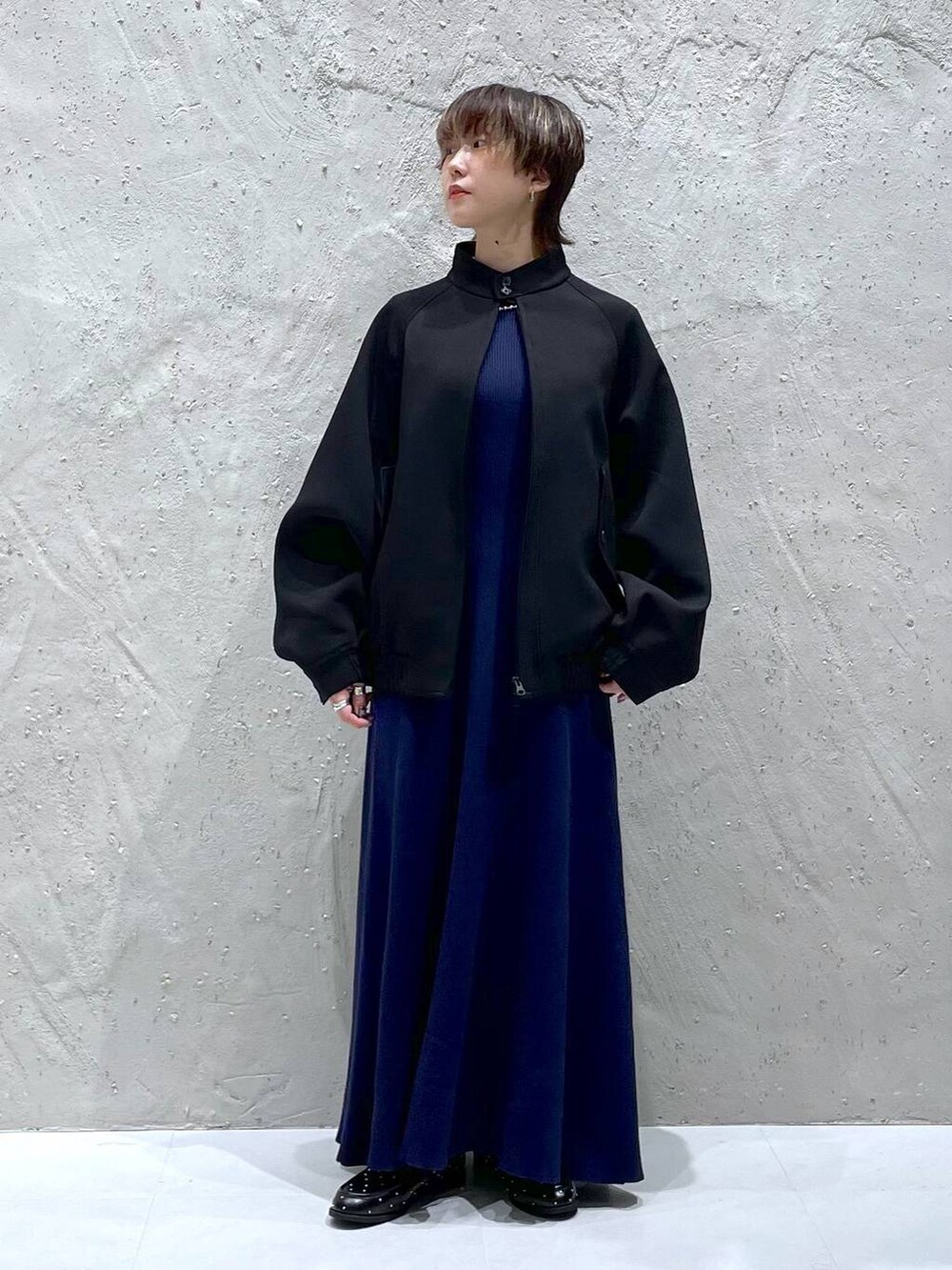 ブラック系のブルゾン、ブルー系のワンピース、ブラック系のローファーを着用したレディースの秋コーディネートの6枚目の写真