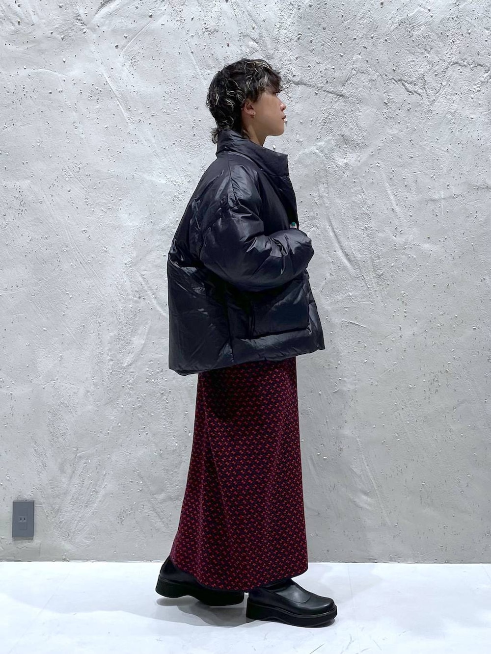 ブラック系のブーツ、ブラック系のダウンジャケット/コート、レッド系のワンピースを着用したレディースの秋コーディネートの2枚目の写真