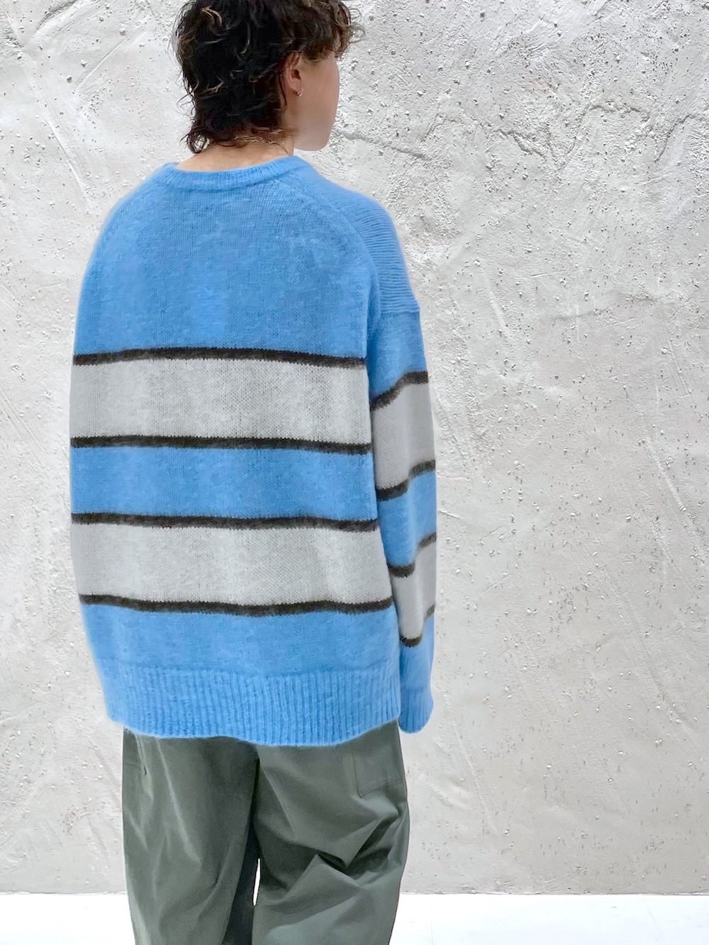 ブルー系のニット/セーター、ブラック系のブーツを着用したレディースの冬コーディネートの3枚目の写真