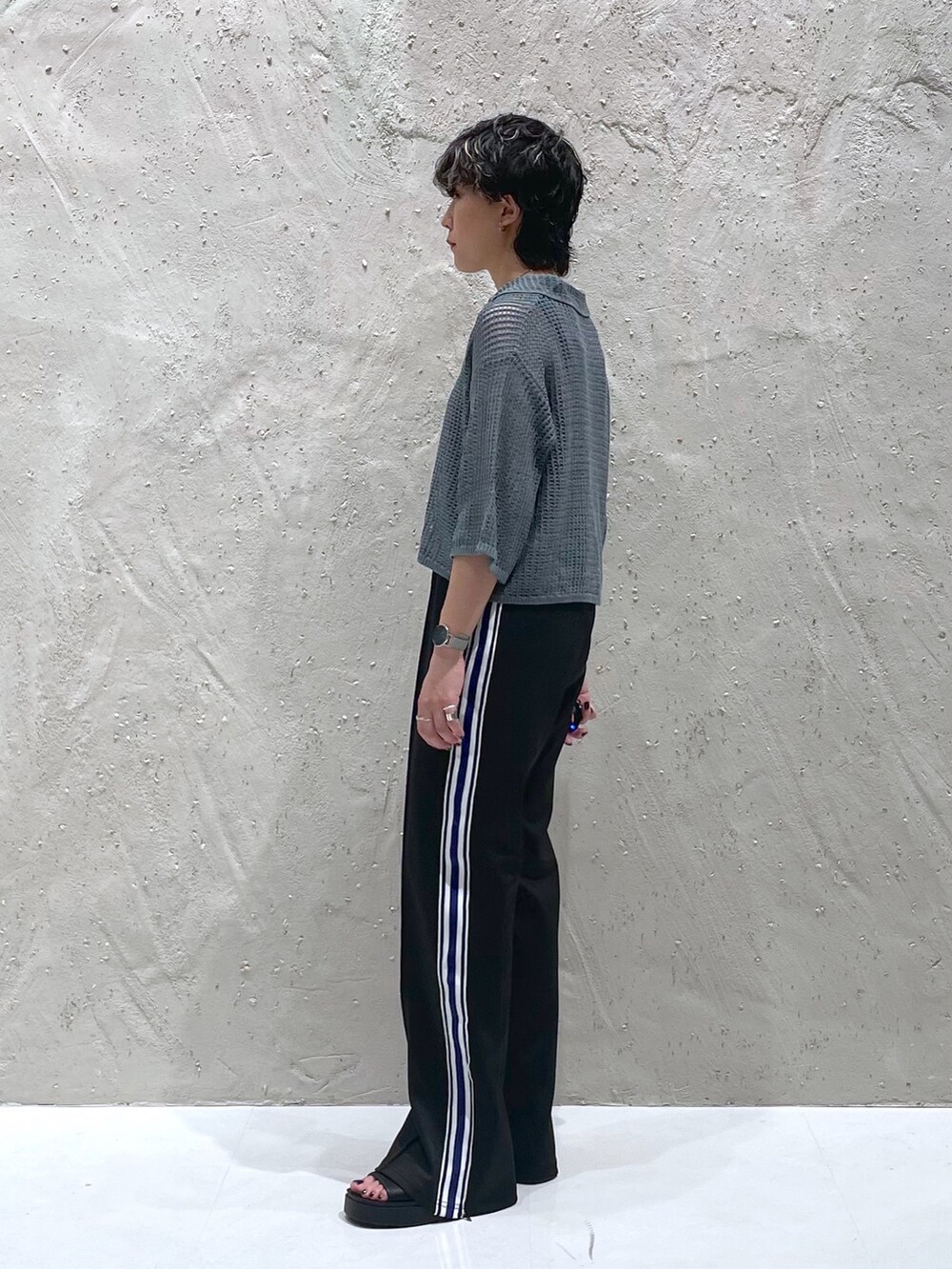 グリーン系のポロシャツ、ブラック系のその他パンツ、ブラック系のサンダルを着用したレディースの夏コーディネートの2枚目の写真