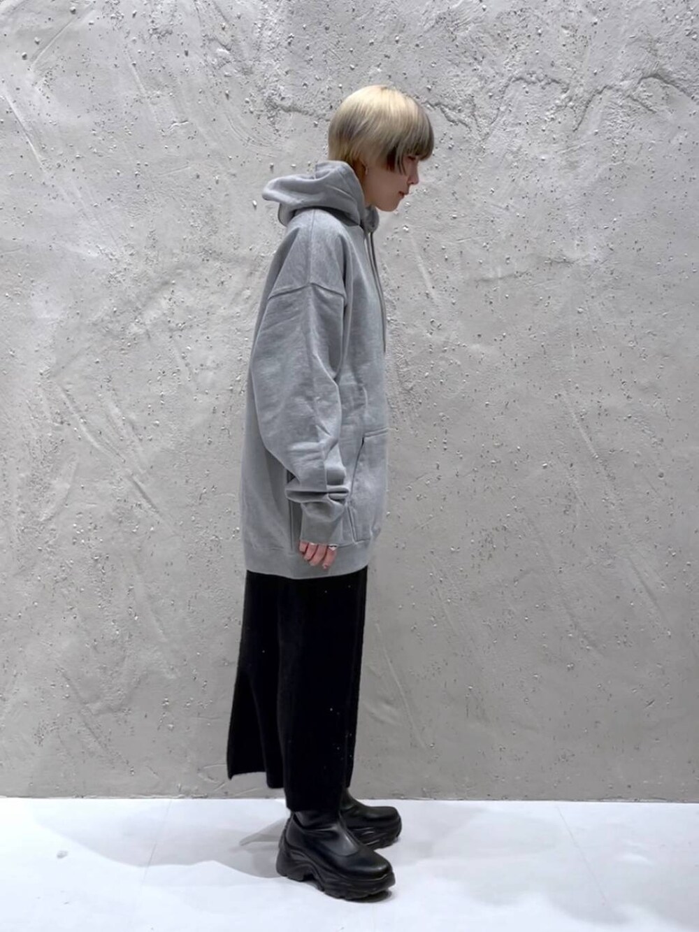 ブラック系のブーツ、ブラック系のスカート、グレー系のスウェットを着用したレディースの冬コーディネートの3枚目の写真