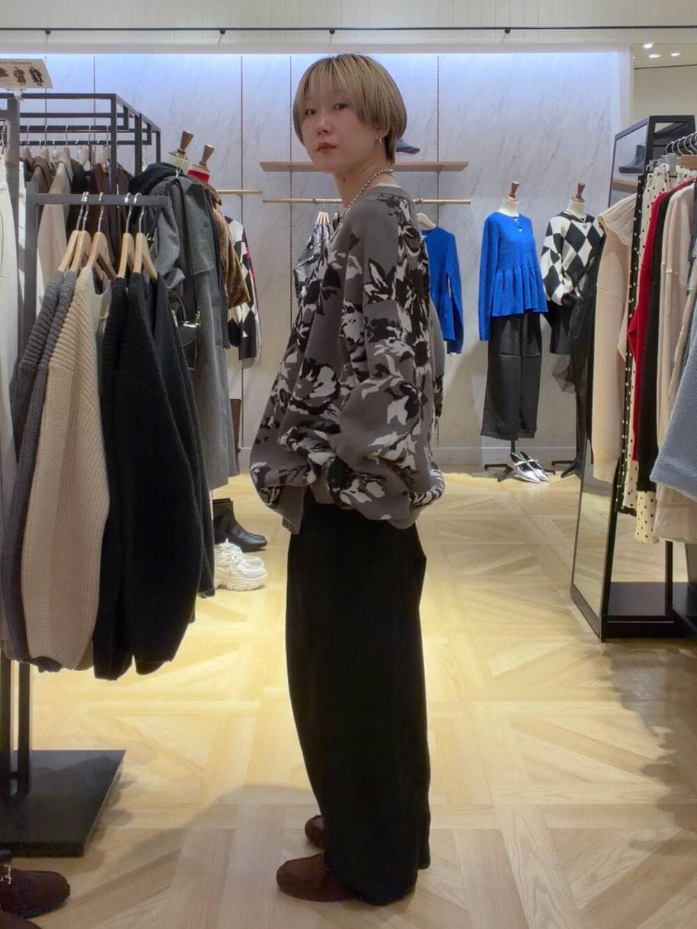 グレー系のカーディガン/ボレロ、グレー系のその他パンツ、ブラウン系のモカシン/デッキシューズを着用したレディースの秋コーディネートの2枚目の写真