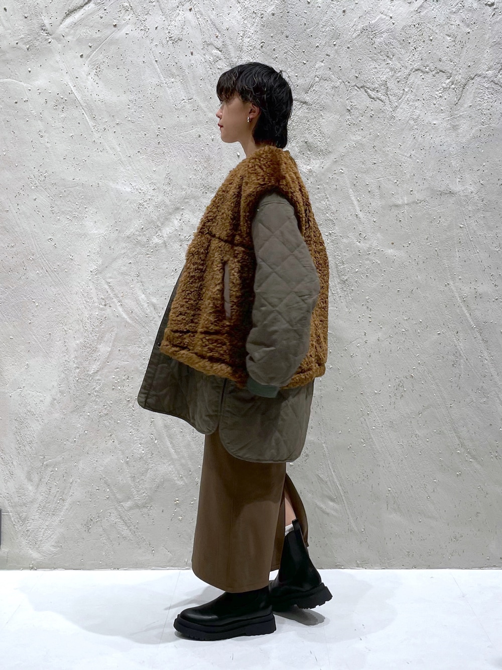 ブルー系のスウェット、グリーン系のブルゾン、ブラック系のブーツを着用したレディースの冬コーディネートの2枚目の写真