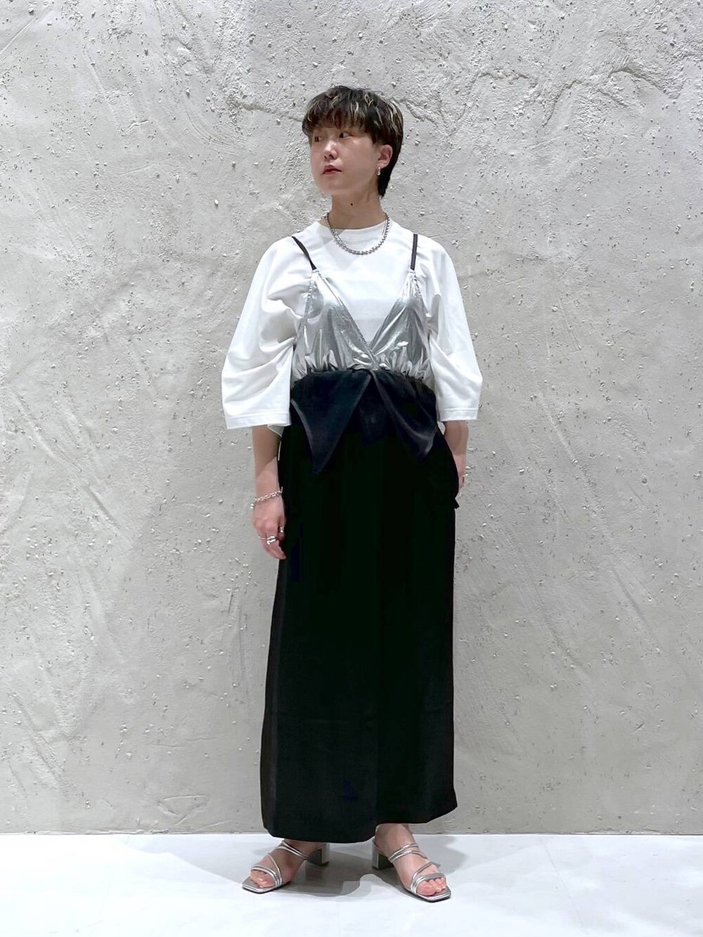 シルバー系のサンダル、ホワイト系のTシャツ/カットソー、ブラック系のワンピースを着用したレディースの春コーディネートの4枚目の写真