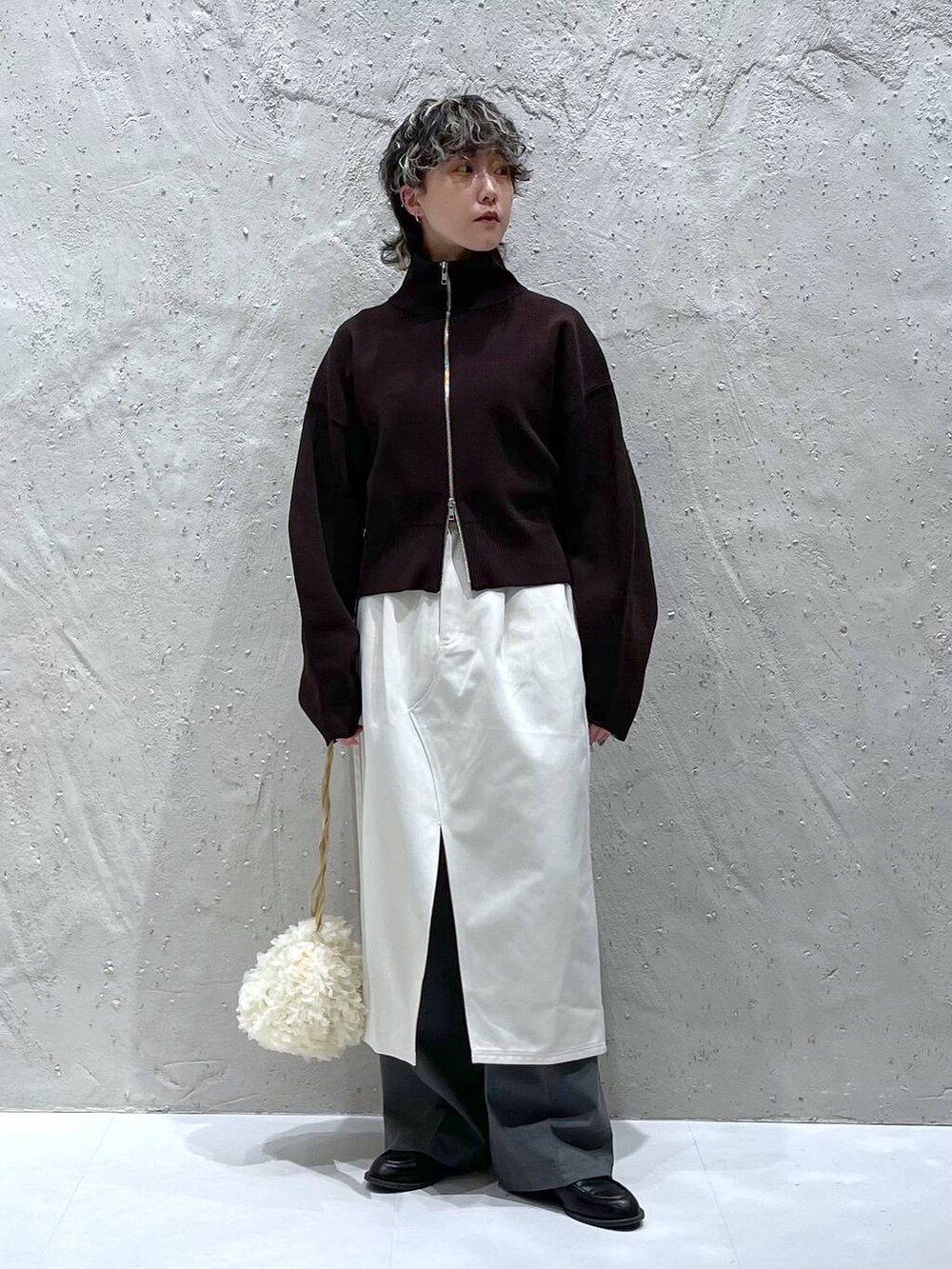 グレー系のその他パンツ、ベージュ系のスカート、ホワイト系のハンドバッグを着用したレディースの春コーディネートの5枚目の写真