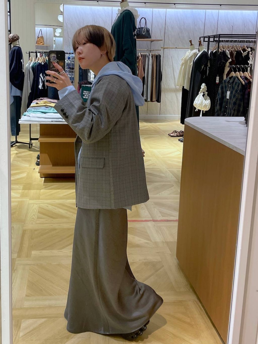 グレー系のスカート、グレー系のテーラードジャケット、グレー系のチューブトップを着用したレディースの秋コーディネートの2枚目の写真