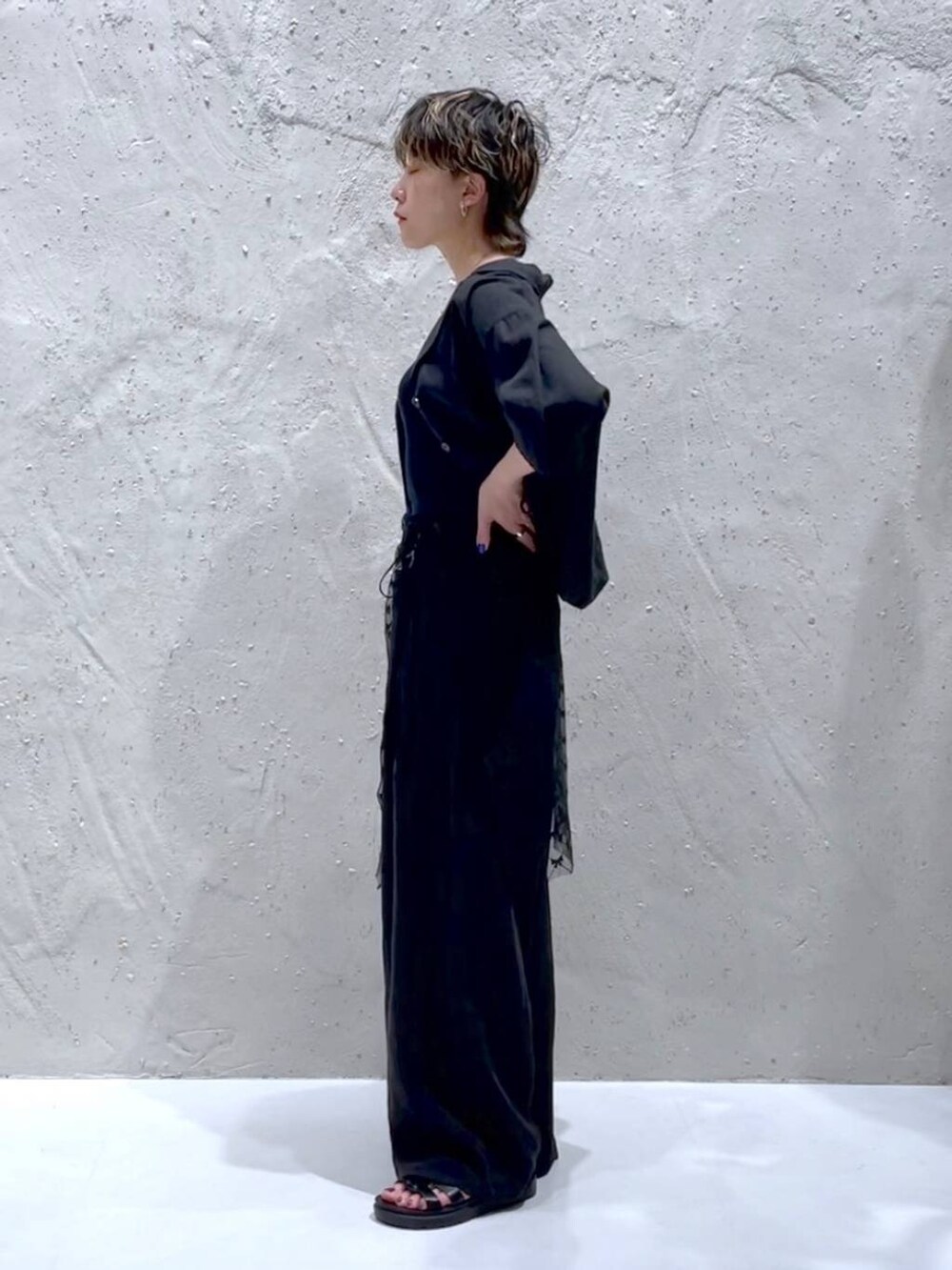 ブラック系のTシャツ/カットソー、ブラック系のスニーカー、グレー系のスラックスを着用したレディースの夏コーディネートの2枚目の写真