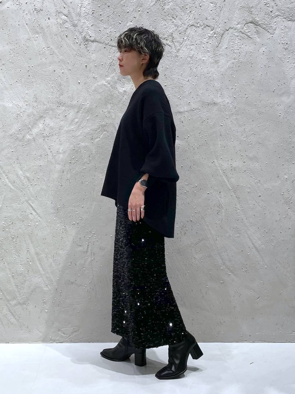 ブラック系のパンプス、ブラック系のニット/セーター、ブラック系のスカートを着用したレディースの秋コーディネートの2枚目の写真