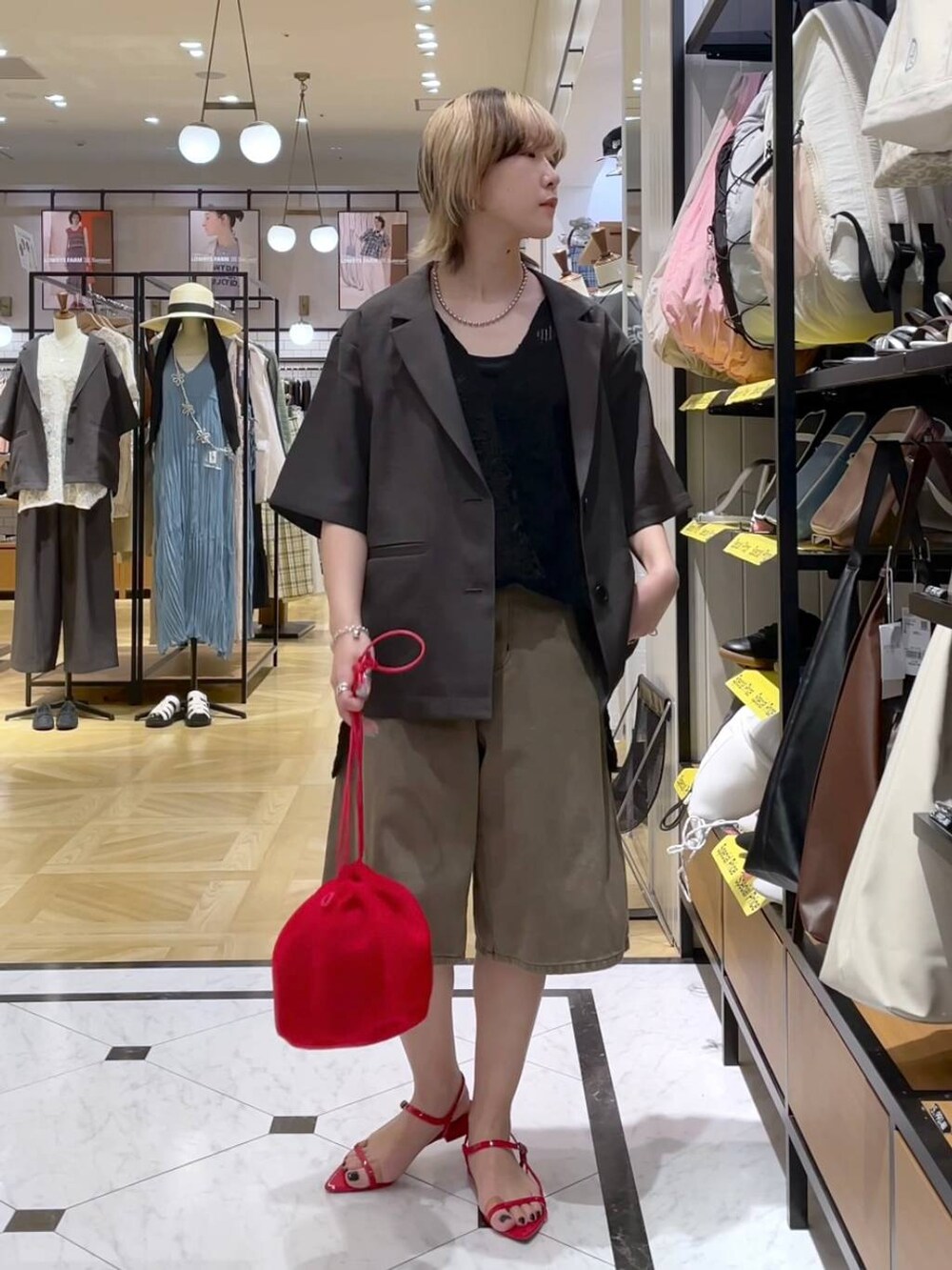 グレー系のテーラードジャケット、レッド系のサンダル、ブラウン系のデニムパンツを着用したレディースの春コーディネートの4枚目の写真