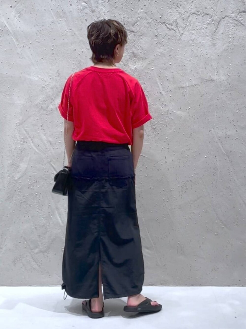 ブラック系のデニムスカート、レッド系のTシャツ/カットソーを着用したレディースの夏コーディネートの3枚目の写真