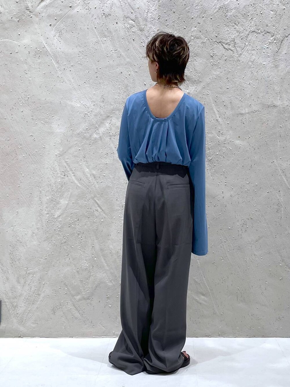 グレー系のスラックス、ブルー系のTシャツ/カットソーを着用したレディースの夏コーディネートの3枚目の写真