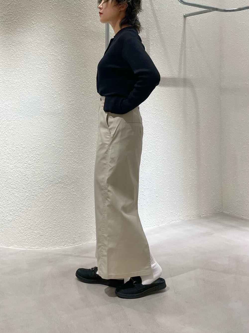 ブラック系のカーディガン/ボレロ、ベージュ系のスカート、ブラック系のローファーを着用したレディースの夏コーディネートの2枚目の写真