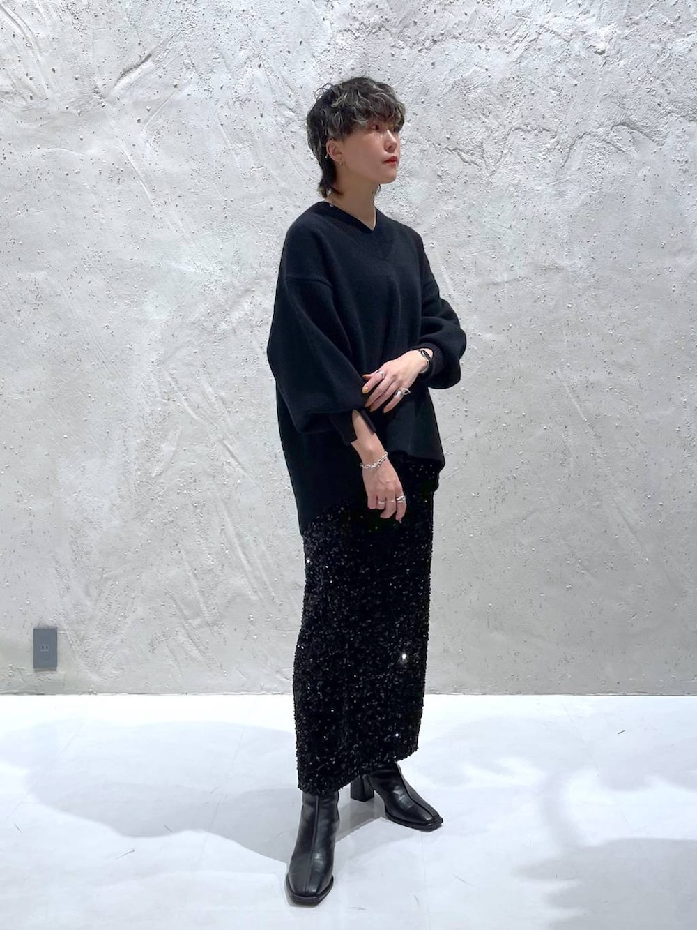 ブラック系のパンプス、ブラック系のニット/セーター、ブラック系のスカートを着用したレディースの秋コーディネートの5枚目の写真