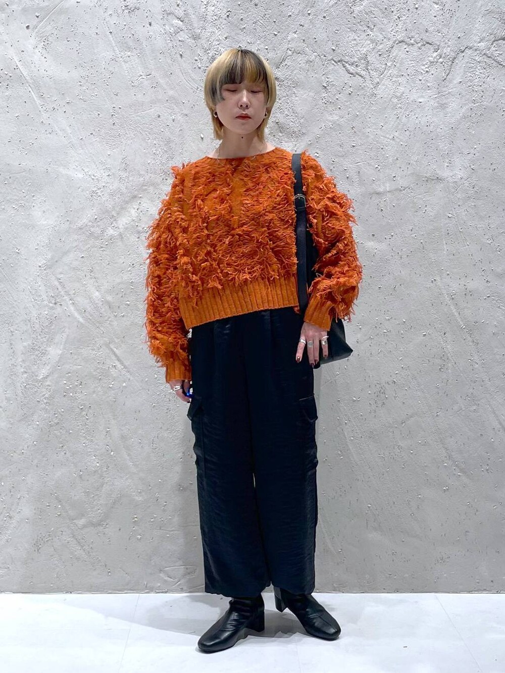 ブラック系のショルダーバッグ、ブラック系のブーツ、ブラック系のカーゴパンツを着用したレディースの秋コーディネートの5枚目の写真