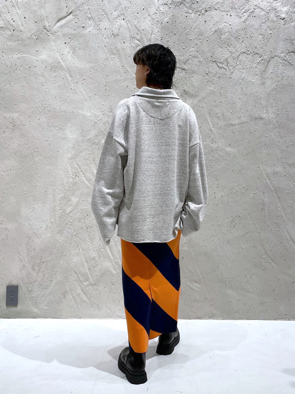 ホワイト系のスウェット、ブルー系のスカート、ブラック系のブーツを着用したレディースの冬コーディネートの4枚目の写真