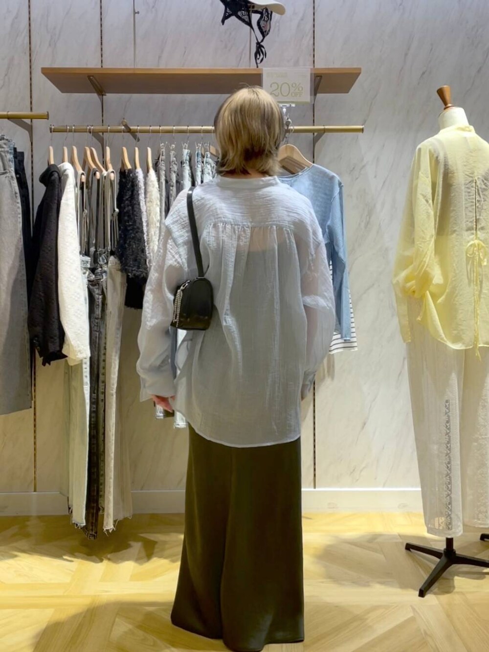 ブラック系のトートバッグ、ブラック系のスニーカー、グレー系のスカートを着用したレディースの春コーディネートの3枚目の写真