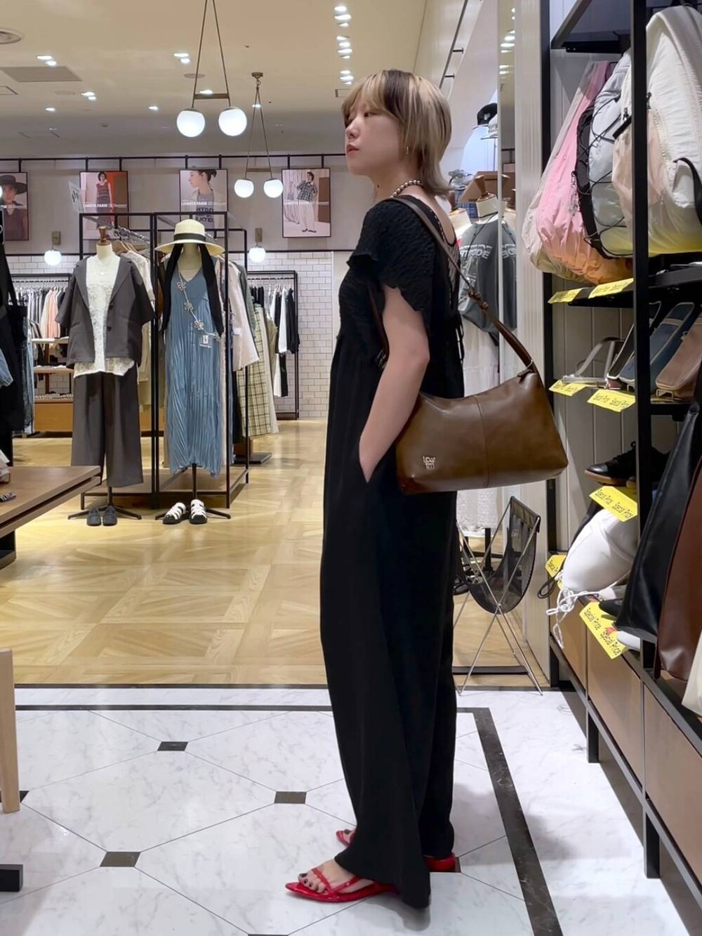 レッド系のサンダル、ブラック系のサロペット/オーバーオール、ブラウン系のショルダーバッグを着用したレディースの春コーディネートの2枚目の写真