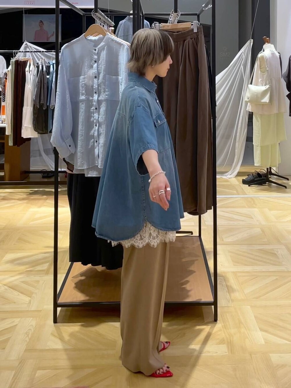 レッド系のサンダル、ブルー系のシャツ/ブラウス、ベージュ系のスラックスを着用したレディースの春コーディネートの4枚目の写真